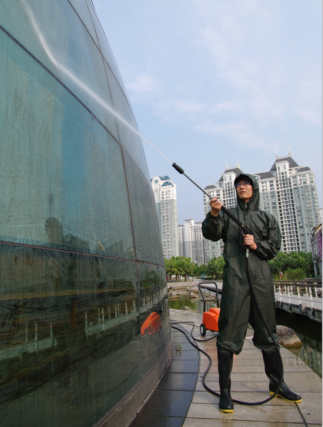 保潔工人正在用高壓清洗機清洗玻離幕墻 保潔工人正在用高壓清洗機清洗玻離幕墻